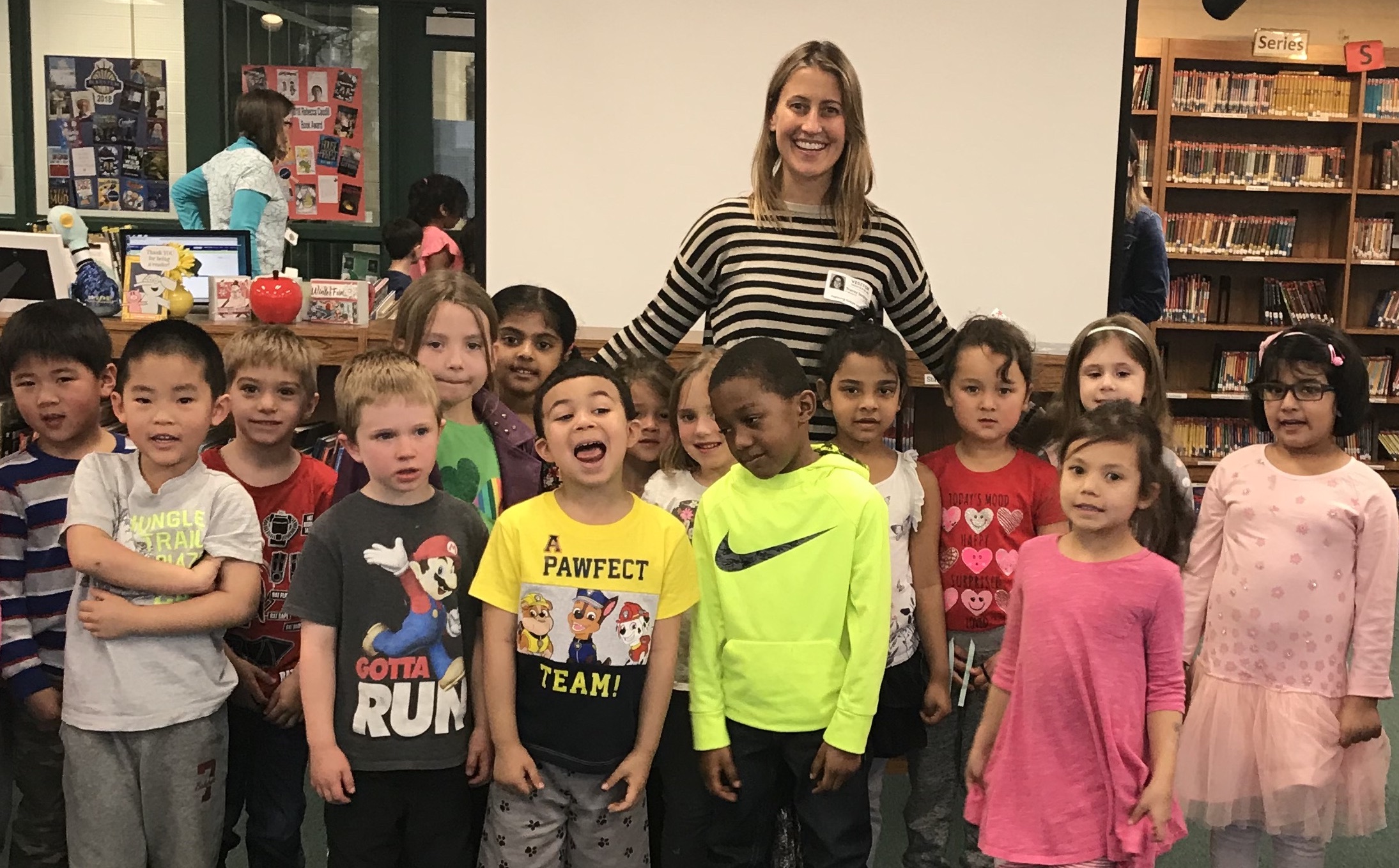 Tracey Hecht, author of The Nocturnals, is smiling in a classroom filled with children who are also posing for the picture.  