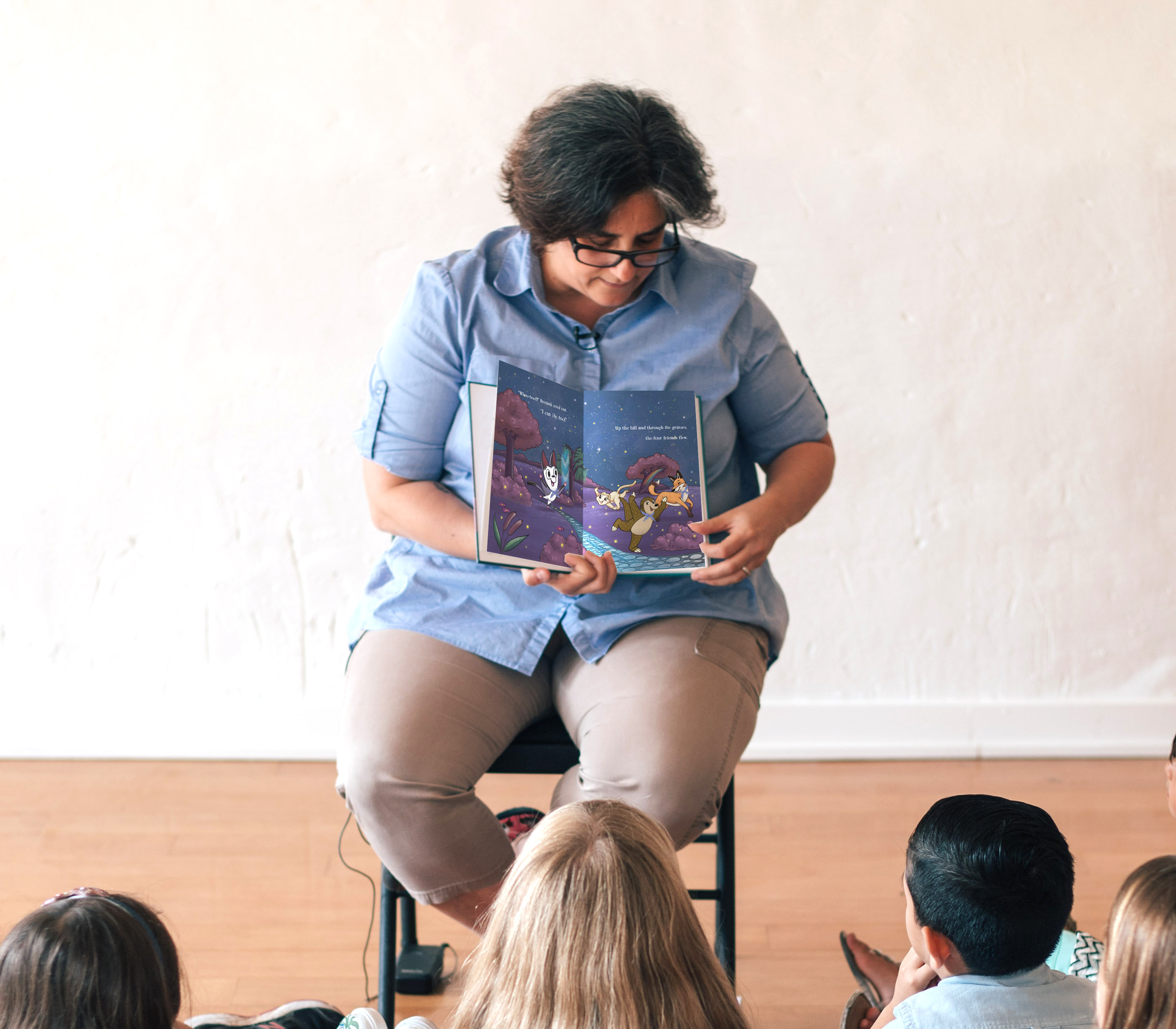 The picture shows a teacher reading The Kooky Kinkajou to the class.