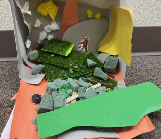 A completed example of the Nocturnals Habitat Activity: a fox diorama made out of paper, cardboard, and other craft supplies.
